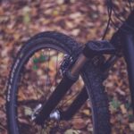 black bicycle wheel on brown leaves