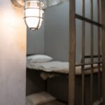 illuminated wall lamp on a concrete wall near steel bars