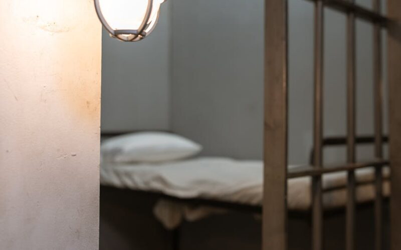 illuminated wall lamp on a concrete wall near steel bars