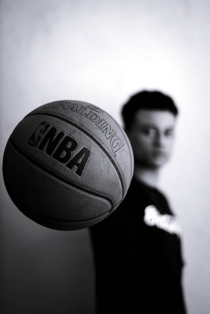 grayscale photo of man holding nba basketball