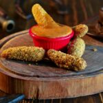 breaded cheese on a wooden chopping board