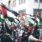 crowd of protesters with palestinian flags