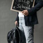a student in black coat holding a black board
